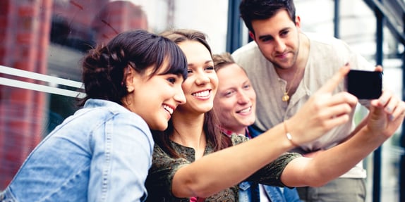 Group of millennials taking a selfie together as part of millennial MROCs